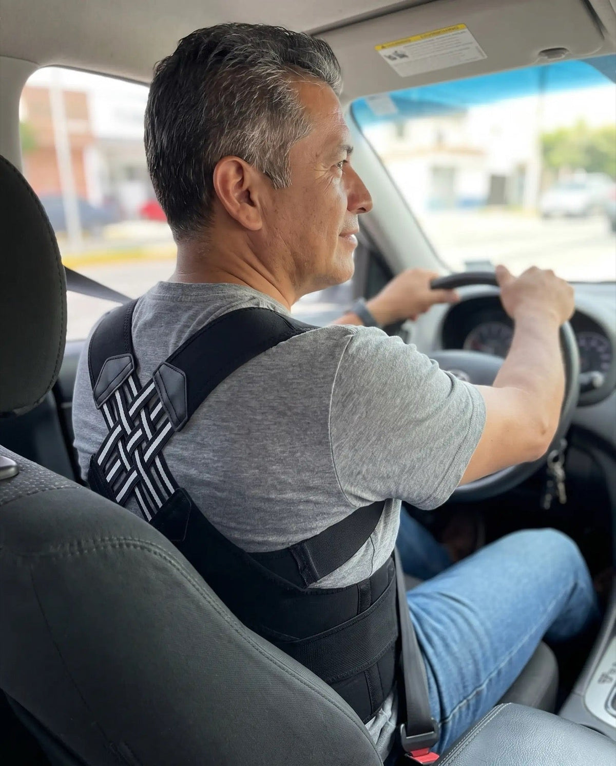 Hombre manejando con el corrector de postura